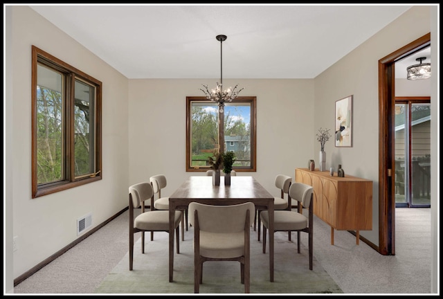 dining area with visible vents, light carpet, baseboards, and a notable chandelier