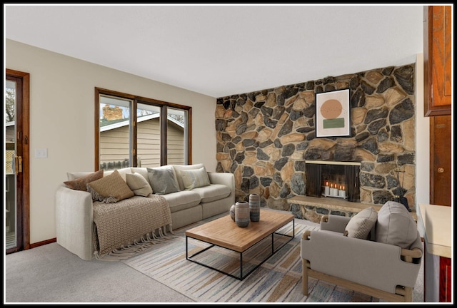 living room with a stone fireplace, a healthy amount of sunlight, and carpet floors