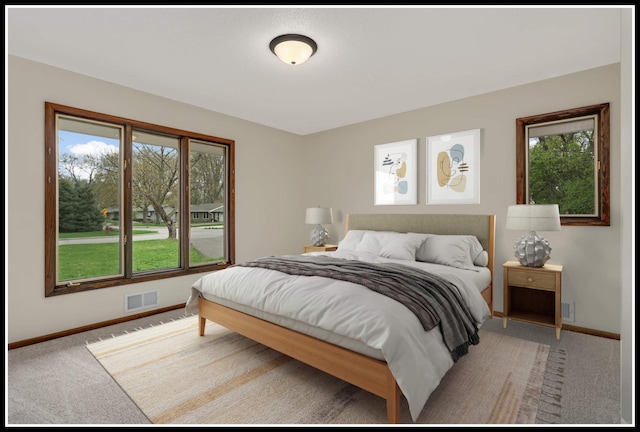 bedroom with light colored carpet, multiple windows, and visible vents
