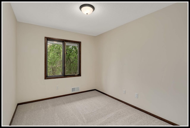 carpeted spare room with baseboards and visible vents