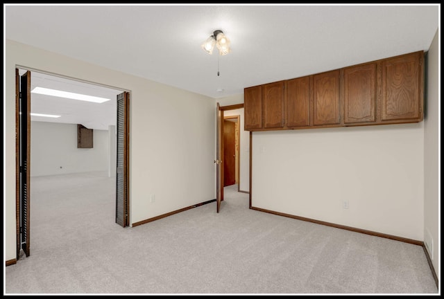 unfurnished bedroom featuring light carpet, a closet, and baseboards