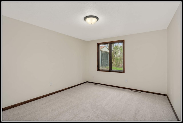 spare room with light carpet, baseboards, and visible vents