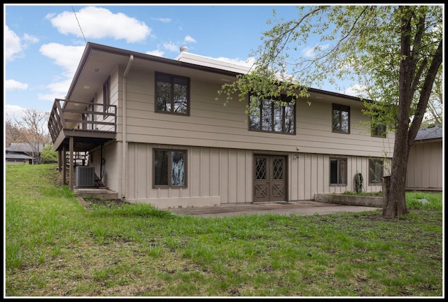 rear view of house featuring a lawn, board and batten siding, stairway, and a wooden deck