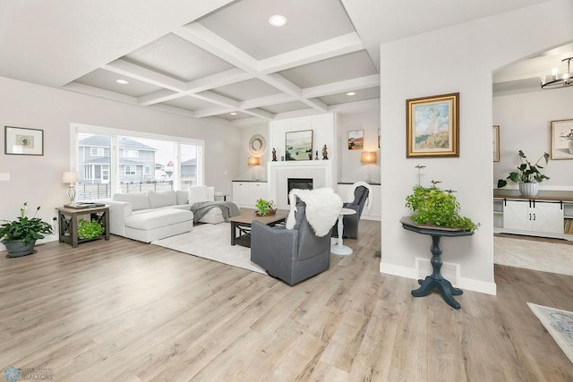 living area featuring baseboards, coffered ceiling, beam ceiling, and light wood-style flooring