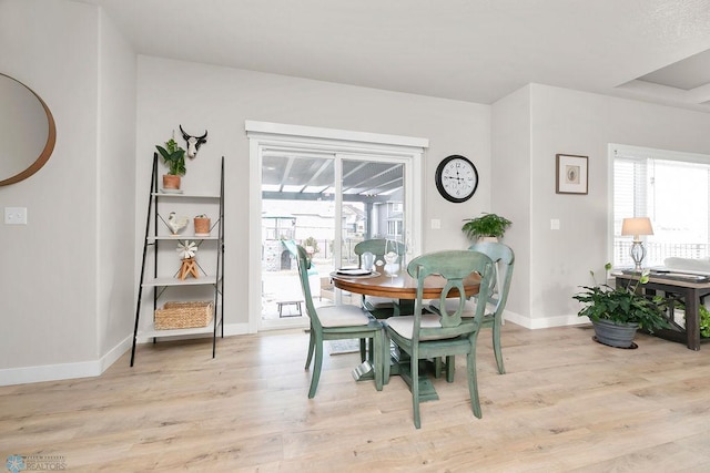 dining space with light wood-type flooring, plenty of natural light, and baseboards