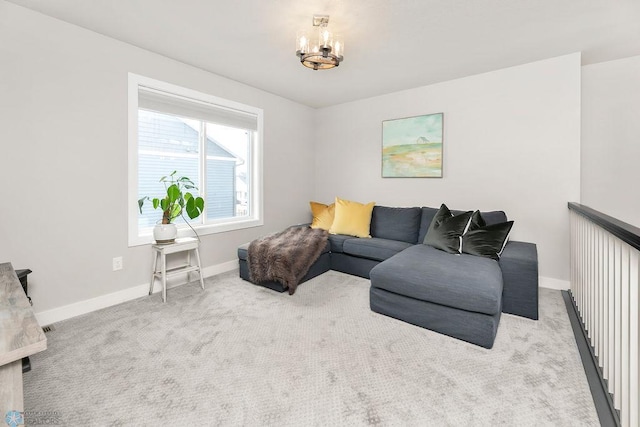 carpeted living room featuring baseboards and a chandelier