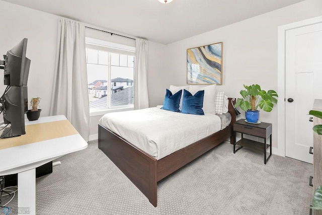 bedroom with baseboards and light carpet