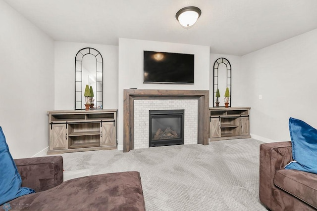 carpeted living area featuring a fireplace and baseboards