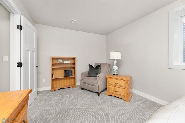 sitting room with baseboards and light colored carpet