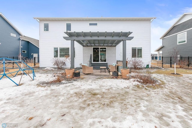 rear view of property featuring a patio area, a pergola, and fence