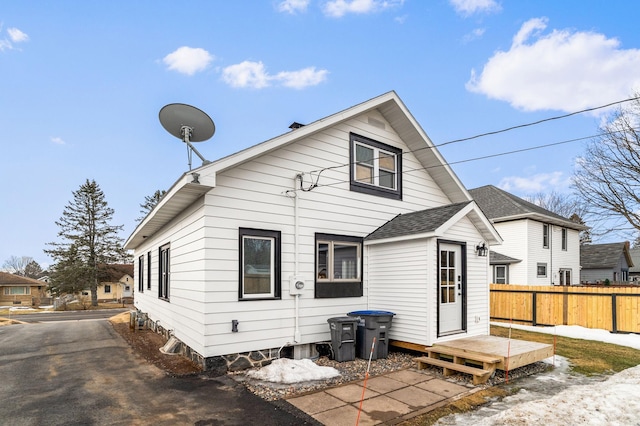 back of house featuring a shingled roof and fence