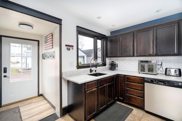 kitchen featuring tasteful backsplash, dishwashing machine, a wealth of natural light, and a sink