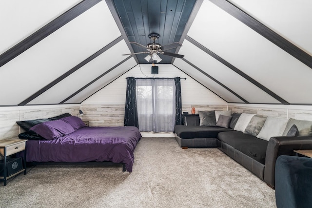 bedroom with lofted ceiling with beams, wooden walls, and carpet