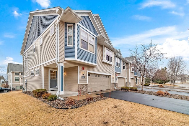 exterior space featuring aphalt driveway, covered porch, a garage, and a residential view