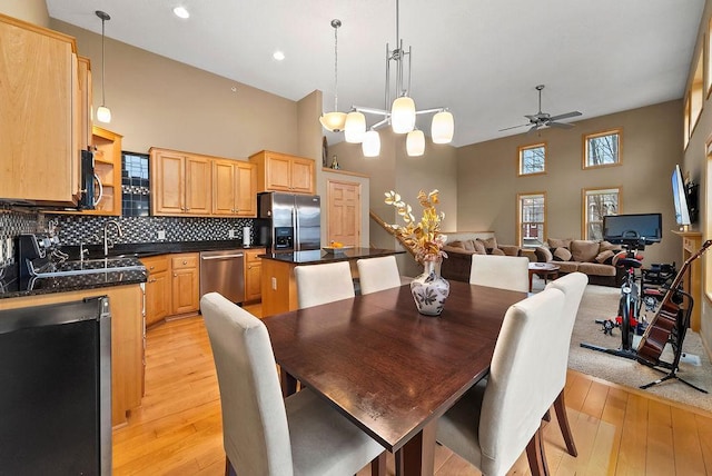 dining room featuring recessed lighting, light wood-style flooring, a high ceiling, and ceiling fan