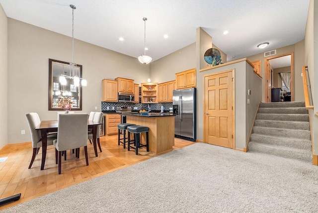 kitchen featuring dark countertops, visible vents, a kitchen island, stainless steel appliances, and open shelves