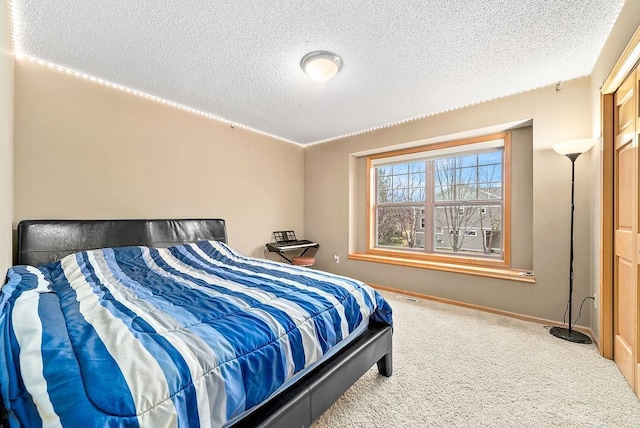 carpeted bedroom featuring visible vents, baseboards, and a textured ceiling