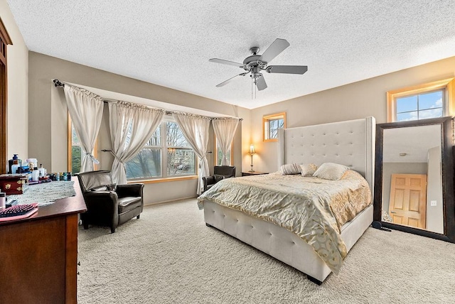 bedroom featuring multiple windows, a ceiling fan, carpet floors, and a textured ceiling