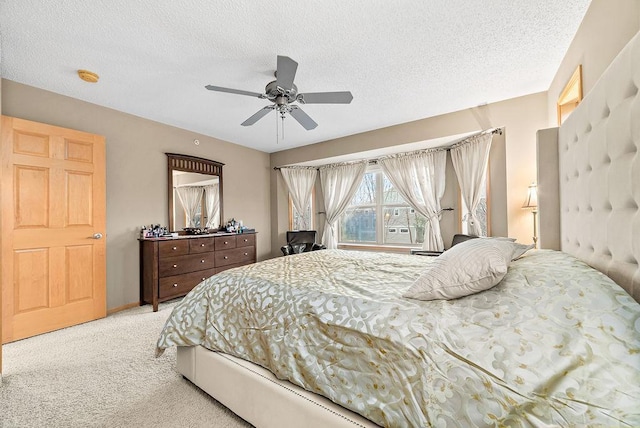 carpeted bedroom with a textured ceiling and ceiling fan