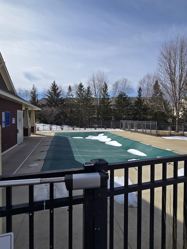 pool with a patio area and fence