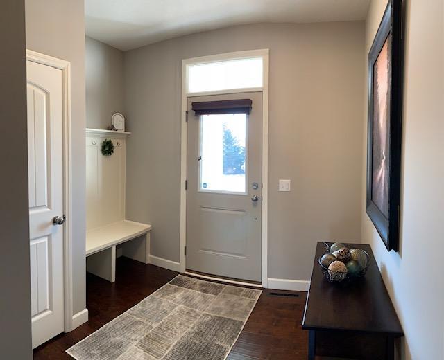 mudroom featuring baseboards and dark wood-style flooring