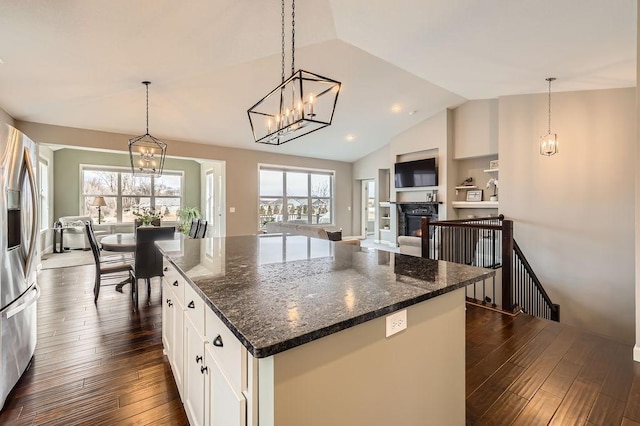 kitchen with open floor plan, white cabinets, stainless steel fridge with ice dispenser, dark wood finished floors, and vaulted ceiling