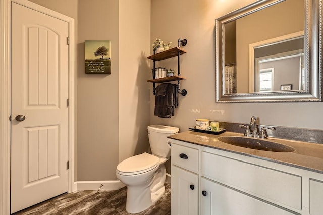 bathroom featuring vanity, baseboards, toilet, and wood finished floors