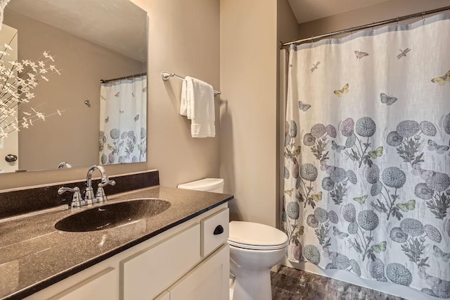 full bath featuring vanity, toilet, curtained shower, and wood finished floors