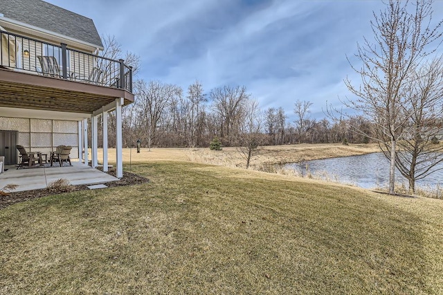 view of yard featuring a deck with water view and a patio