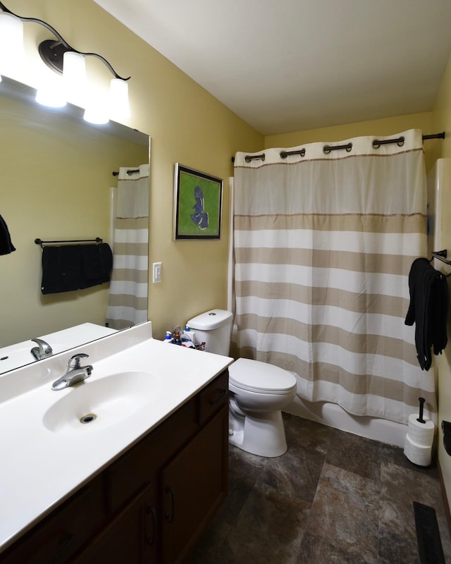 full bath featuring visible vents, stone finish floor, toilet, and vanity