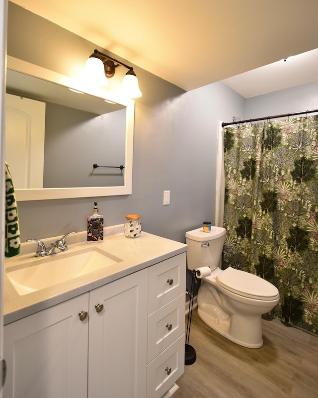 full bath with a shower with curtain, toilet, wood finished floors, and vanity