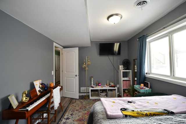 bedroom featuring visible vents and wood finished floors