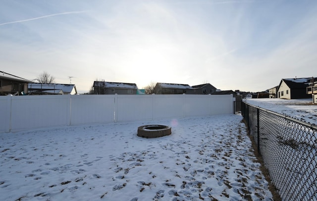 snowy yard with a residential view and a fenced backyard