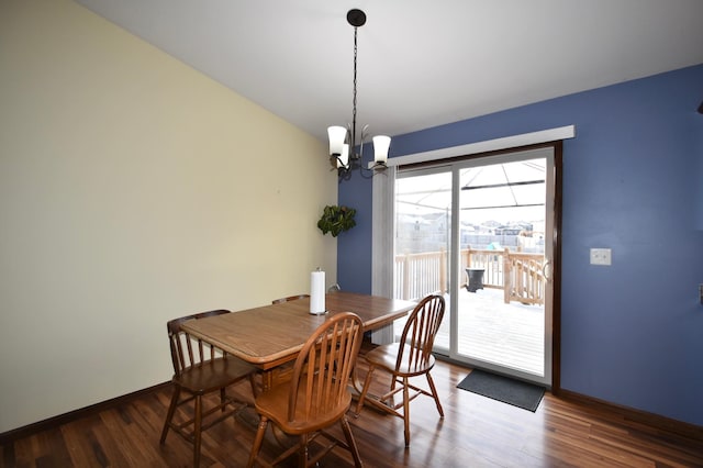 dining space featuring wood finished floors, baseboards, and a chandelier