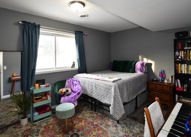 bedroom featuring visible vents and wood finished floors