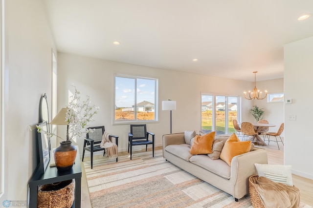 living area featuring recessed lighting, light wood-style floors, a notable chandelier, and a healthy amount of sunlight