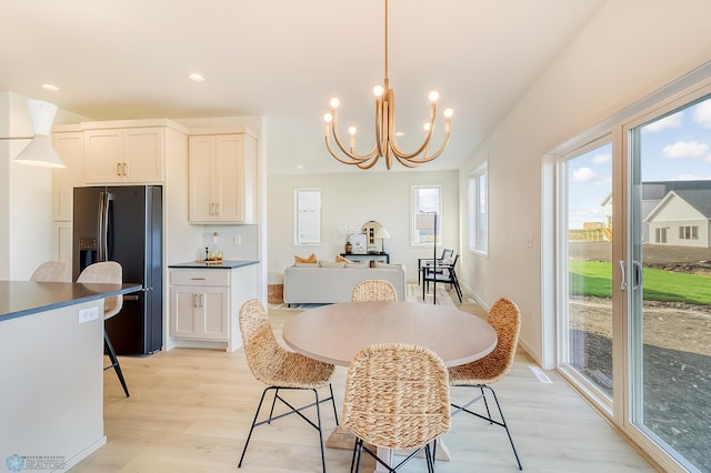 dining space with recessed lighting, baseboards, light wood-style floors, and an inviting chandelier