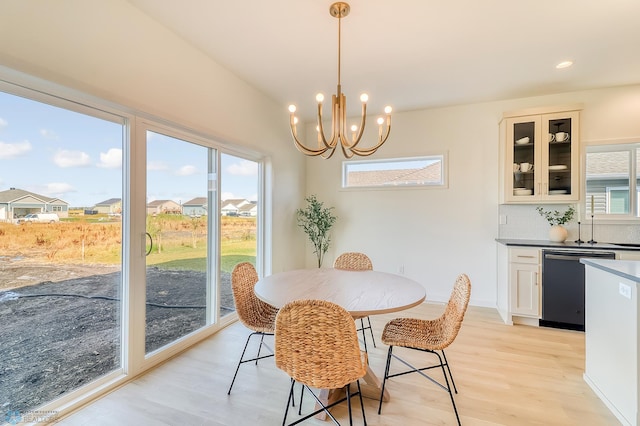 dining room with recessed lighting, an inviting chandelier, and light wood-style flooring