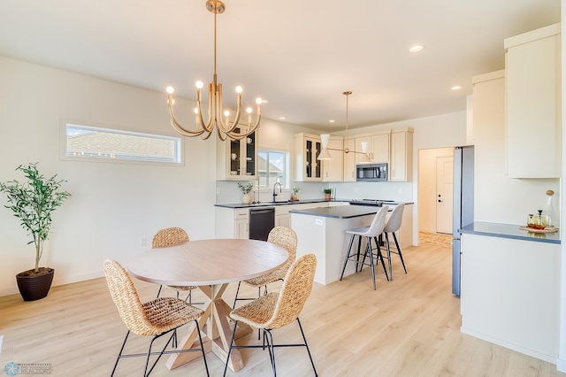 dining room with recessed lighting, light wood-style floors, baseboards, and a chandelier