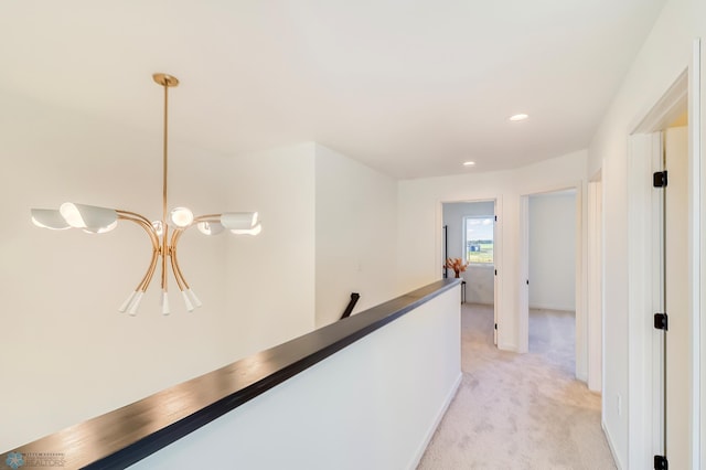 corridor with recessed lighting, an upstairs landing, a chandelier, and light carpet