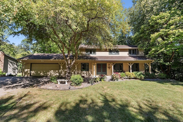 view of front of property with covered porch, driveway, a front lawn, and a garage