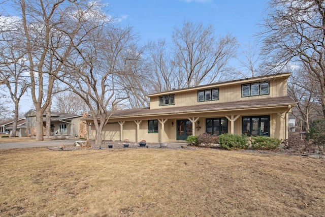 view of front facade with a porch, a front yard, and a garage