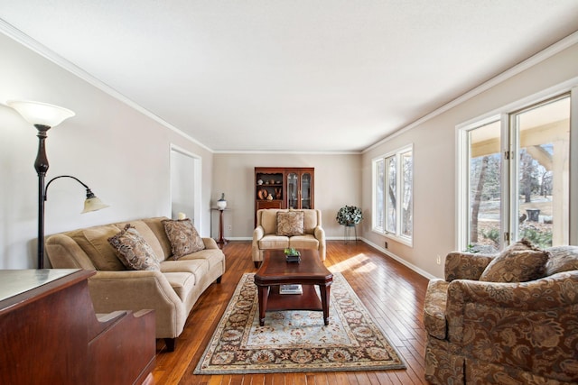 living area with baseboards, wood-type flooring, and ornamental molding