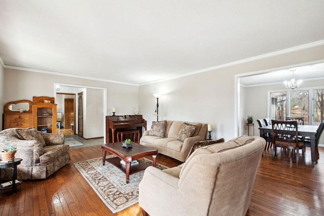 living area featuring a chandelier, dark wood-style flooring, and ornamental molding