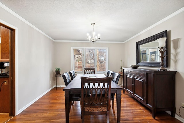 dining area with ornamental molding, baseboards, dark wood-style flooring, and a chandelier