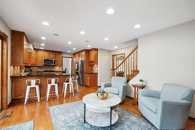 living area with stairs, light wood-style flooring, recessed lighting, and visible vents