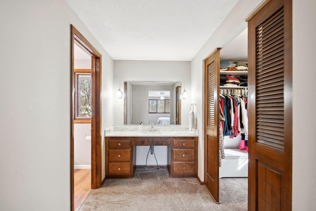 bathroom with a wealth of natural light, connected bathroom, vanity, and baseboards