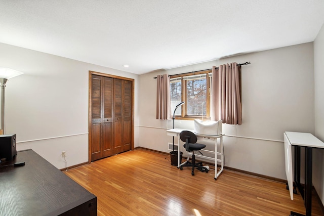 office space featuring baseboards and light wood-type flooring