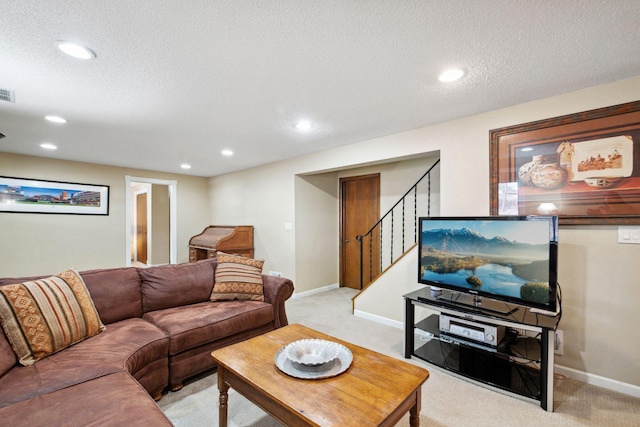 living room featuring stairway, light colored carpet, a textured ceiling, and baseboards