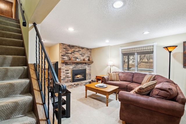 carpeted living room featuring recessed lighting, stairway, a textured ceiling, and a brick fireplace